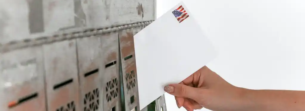 Woman placing a stamped envelope into a mailbox